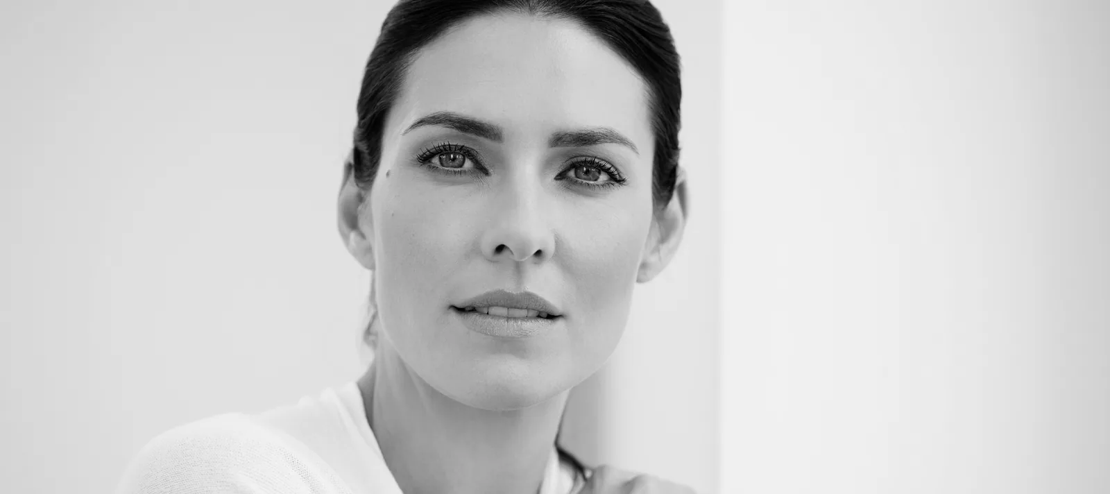 Portrait en noir et blanc d'une patiente au visage lisse et raffermi, illustrant un lifting cervico-facial réalisé par le Dr Pulvermacker à Paris