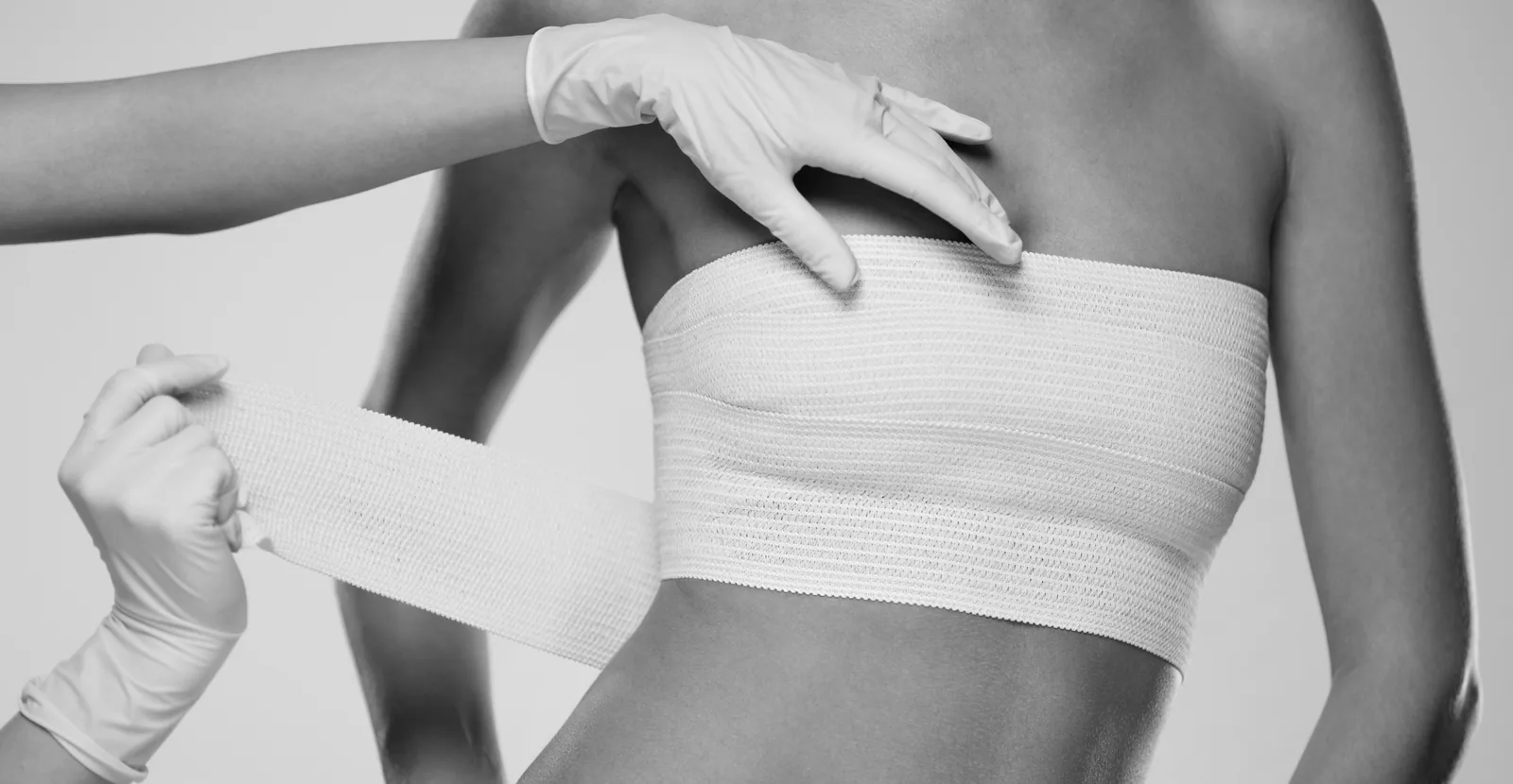 Pose d'un bandage compressif sur la poitrine après une intervention pour ptose mammaire réalisée par le Dr Pulvermacker à Paris